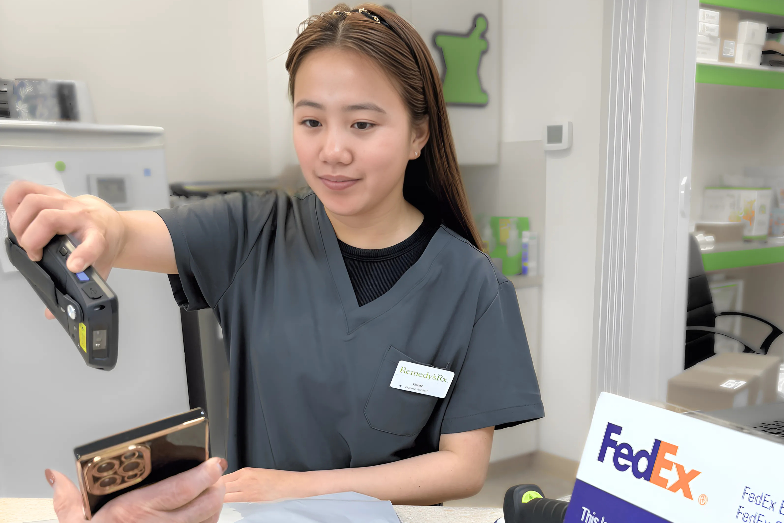 Pharmacy assistant scanning a barcode from a customer’s phone at the courier counter
